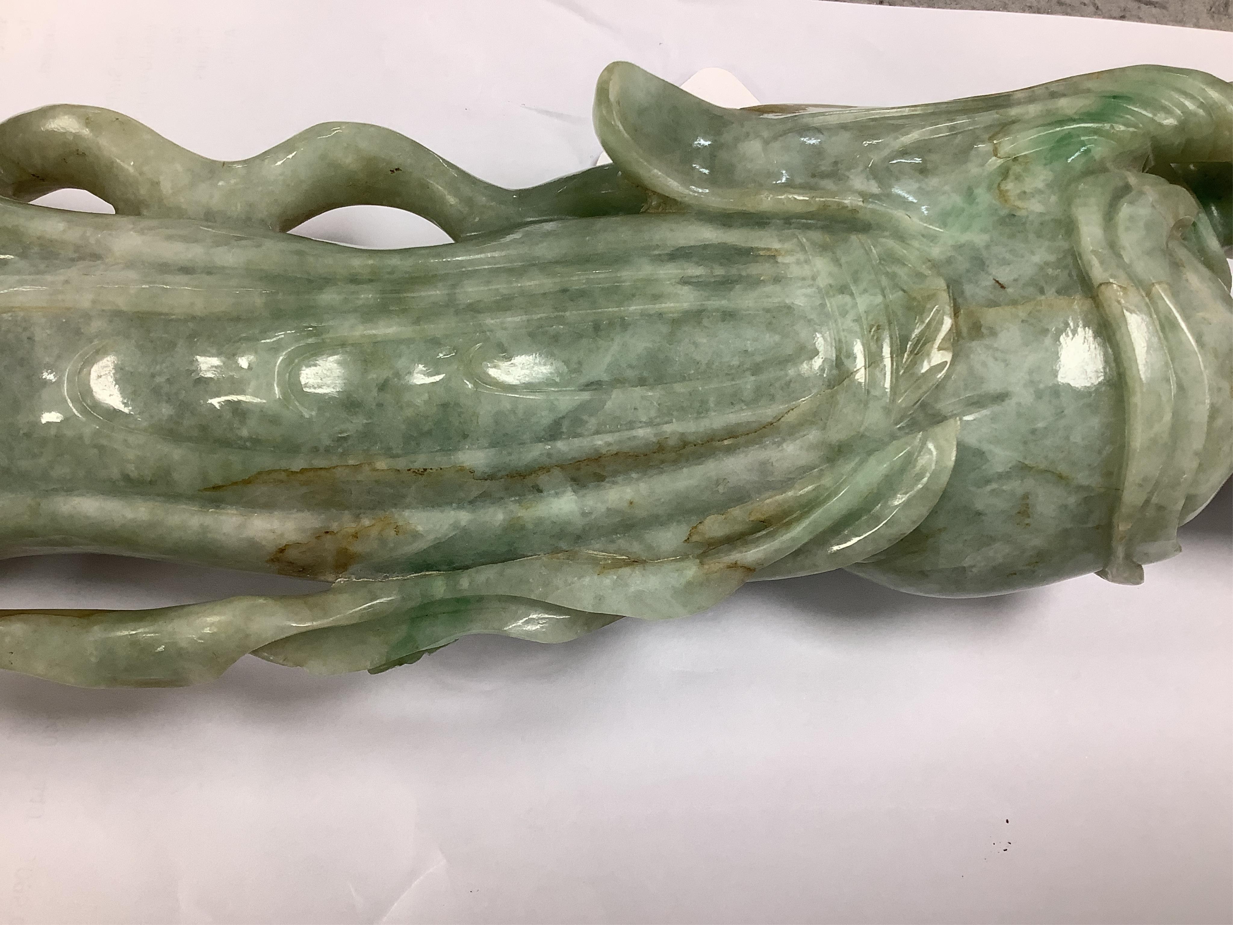 A Chinese jadeite carving of Guanyin, on associated hardwood stand, 38cm high. Condition - fair